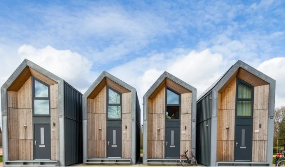 Moderne houten tiny houses met zadeldak, blauwe lucht.
